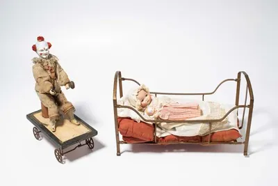 Schuler Auktionen AG - Lot: Ziehspielzeug "Clown" und Bébé in Bettchen